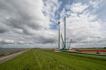 Bouw van een moderne windmolen aan de dijk in Nederland