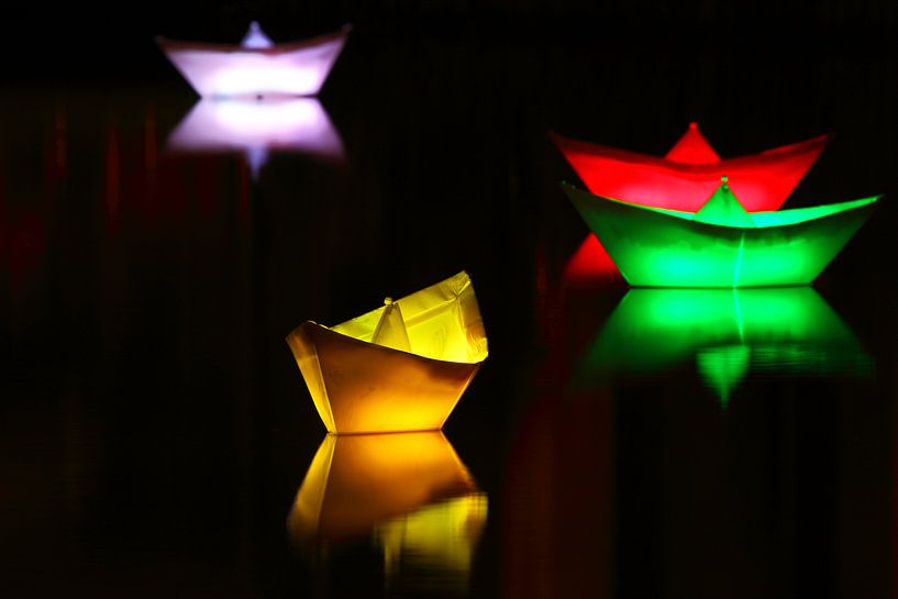 Beleuchtete Schiffchen auf einem See in der Nacht von Frank Herrmann
