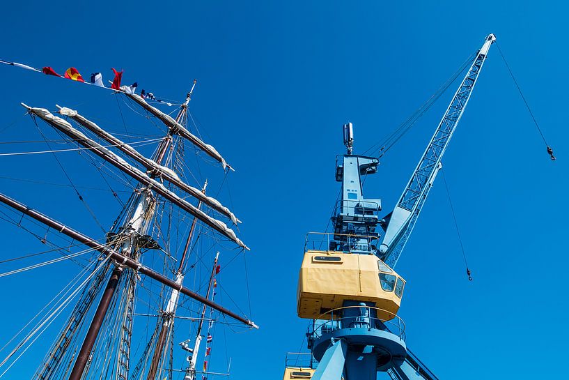 Segelschiff und Hafenkran im Stadthafen von Rostock van Rico Ködder