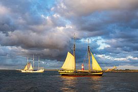 The windmill tower and sailing ships on the Baltic Sea in Warnemünde by Rico Ködder