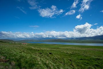 Islande - Lac bleu entre champs verts et montagnes sur adventure-photos