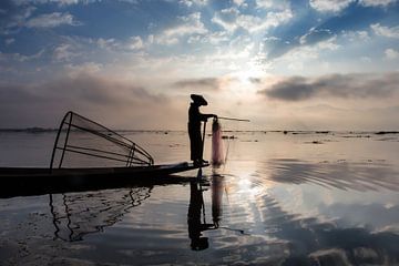 FISHERMAN AT SUNRISE vist ON TRADITIONAL WAY TO INLE LAKE IN MYANMAR. With a basket the fish is caug by Wout Kok