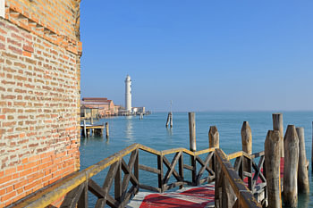 Murano lighthouse and brick wall along Venetian lagoon