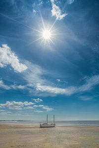 Bootje op t droge bij eb op het strand van Harlingen, Friesland.