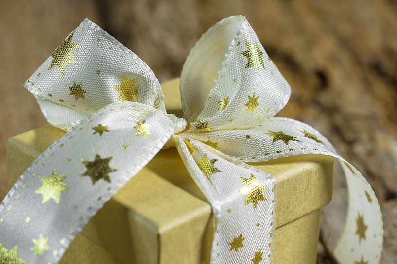 Kerstmisgeschenk met gouden stervormige lintboog op houten lijst, exemplaarruimte van Alex Winter