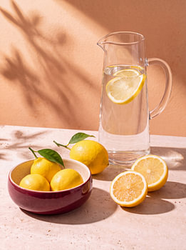 Zitronen und eine Karaffe Zitronenwasser