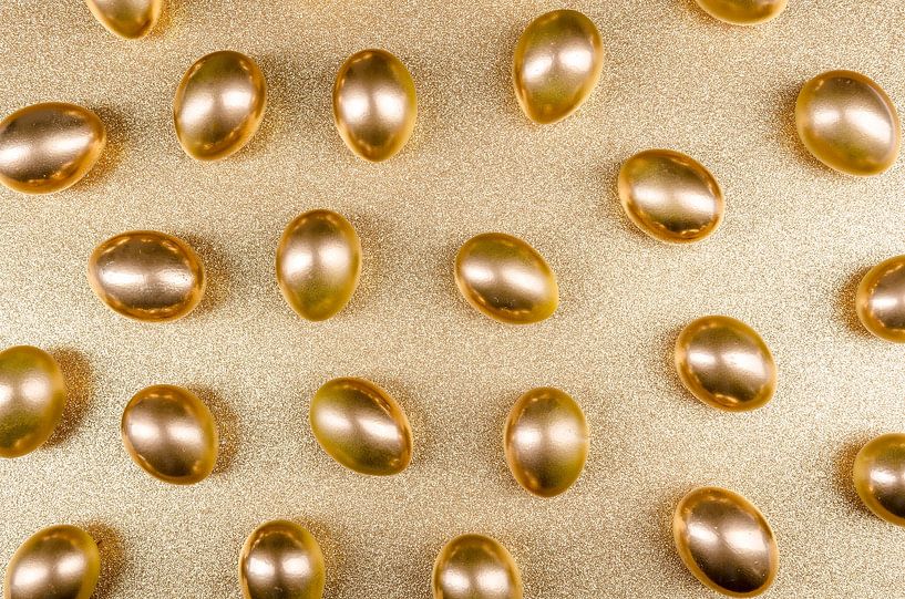 Goldene Eier auf glitzerndem Untergrund von Alexander Baumann