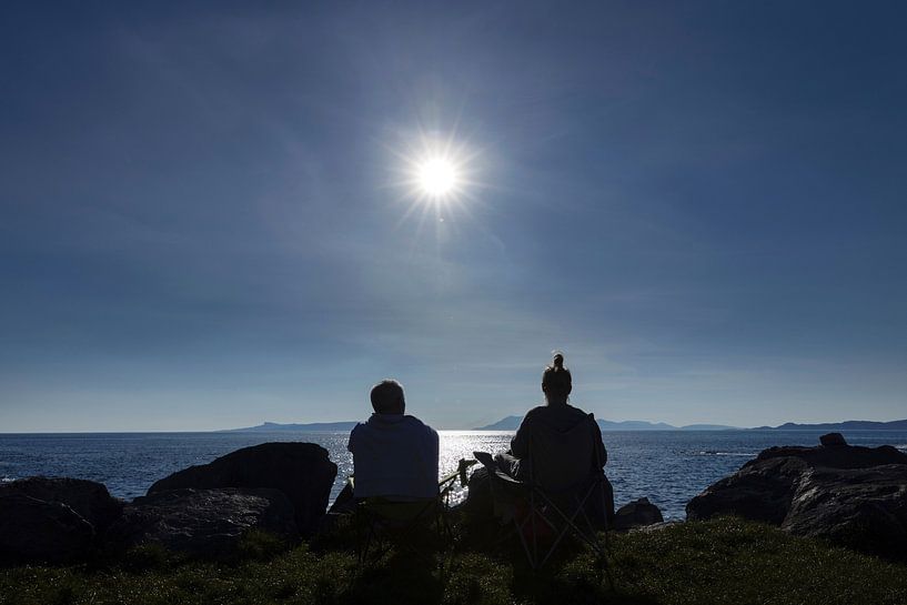 Mann und Frau in Silhouette mit Blick über das Meer. Sonnenuntergang in Mallaig im schottischen Hochland. von Albert Brunsting