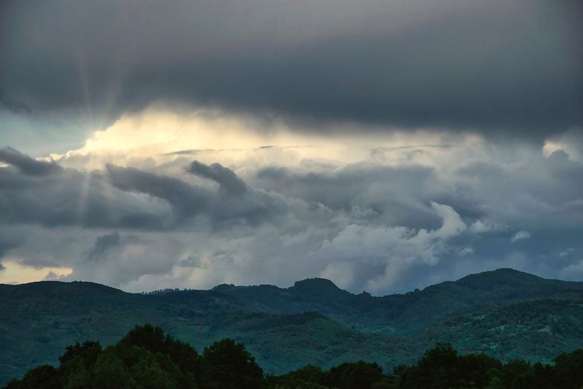 Sonnenschein durch stürmische Wolken über den Bergen von Andreea Eva Herczegh