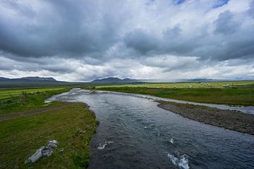 Islande - Rivière entre des champs verdoyants remplis de bottes de foin à la saison des récoltes sur adventure-photos