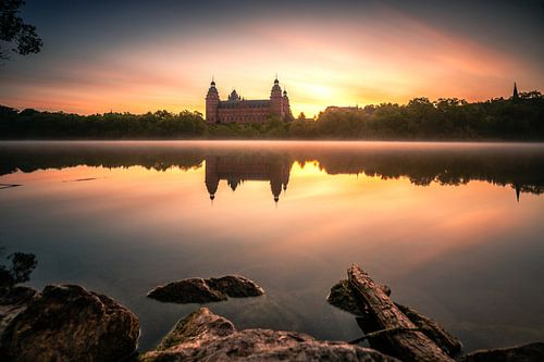 Het kasteel Johannisburg in Aschaffenburg Duitsland in de mist en de zonsopgang met reflectie