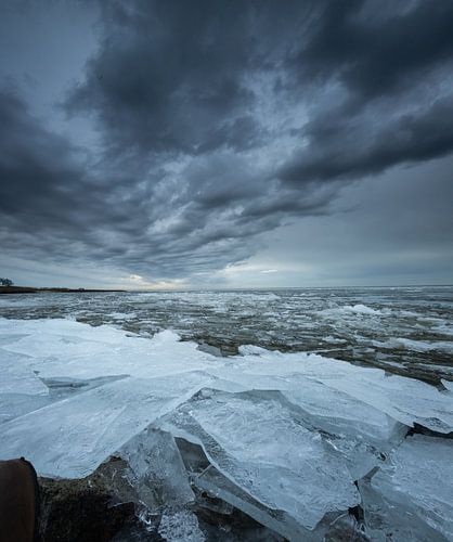 Regenbui boven een bevroren IJsselmeer