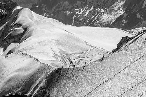 Bergbeklimmers op een bergrug in besneeuwd landschap (zwart-wit)