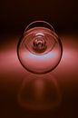 Wijn glas op zacht rood gekleurde ondergrond van Kim Willems thumbnail