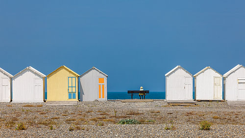 Dame rust uit tussen de strandhuisjes
