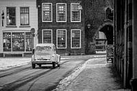 Klassieke Franse Citroën 2CV op een besneeuwde straat in de oude stad