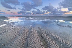 Ebb à la plage de Westerschouwen sur Schouwen Duivenland en Zélande. Les nuages se reflètent dans l'