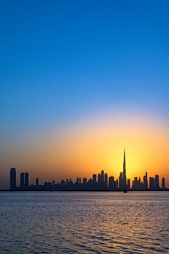 Warme zonsondergang met de skyline van Dubai