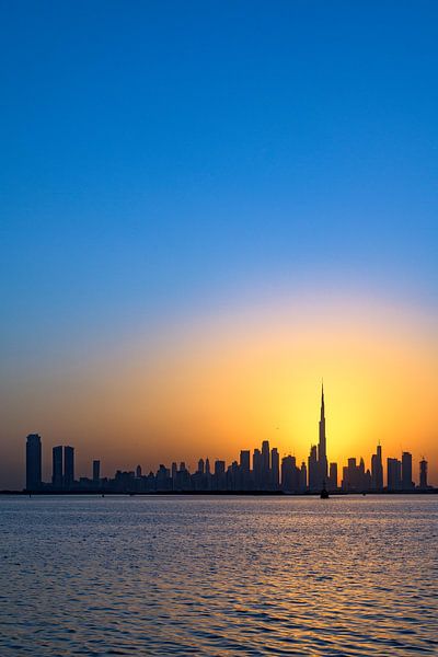 Warme zonsondergang met de skyline van Dubai van Dirk Verwoerd