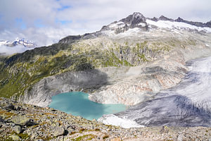 Sommerliche Berglandschaft in der Schweiz mit grünen Almen und markanten Gipfeln.