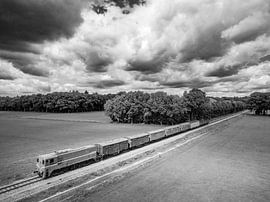 Old diesel freight train in the countryside seen from above