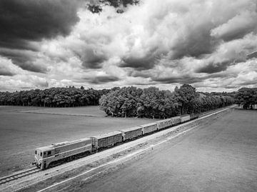 Oude dieselgoederentrein op het platteland van bovenaf gezien