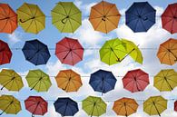 parapluies colorés suspendus dans le ciel, deux flirtent, décor de rue en arrière-plan par Maren Winter Aperçu