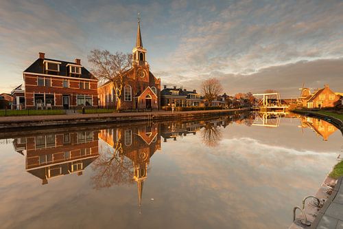 Kerk en molen van Birdaard weerspiegeld in het water bij zonsondergang