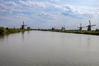 Kinderdijk, une vieille image néerlandaise : des moulins à vent, de l'eau et un ciel couvert.
