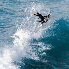 Pro Surfer flying high out of a wave by massimo pardini