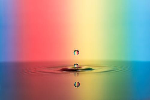 Kleurrijke waterdruppel valt in het water