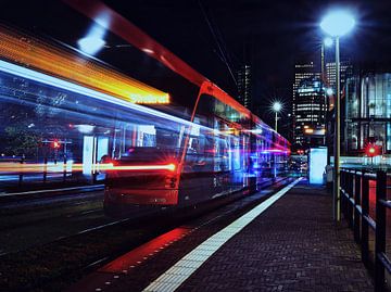 Tram bij nacht voor de skyline van Den Haag van Michiel van den Bos