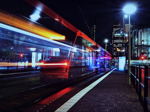 Tram bij nacht voor de skyline van Den Haag