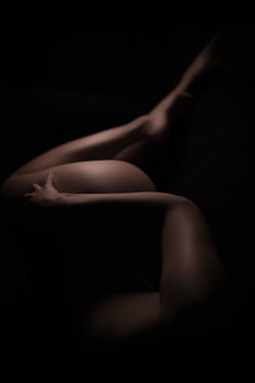 nackter Körper einer Frau in Schatten und weichem Licht in Farbe