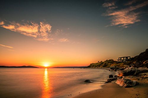 Zonsondergang aan de kust van Griekenland met strand en stenen
