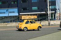 Een fiat 500 met een doodskist op het dak