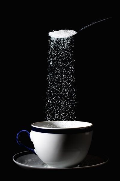 Image abstraite d'une tasse avec du sucre qui tombe dedans. par Jolanda Aalbers