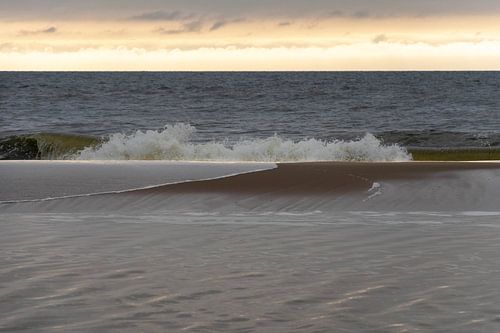Le soleil est sur le point de se coucher et la marée monte au bord de la mer sur Lisette Rijkers