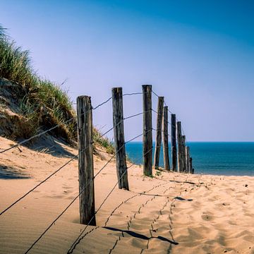 Zaun am Strandeingang mit Dünen, Strand und Meer. von Jeroen