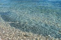 Helder water en stenen in een mediterrane baai