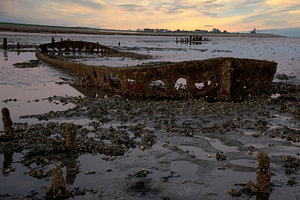 Sonnenuntergang am Wattenmeer mit einem Schiffswrack