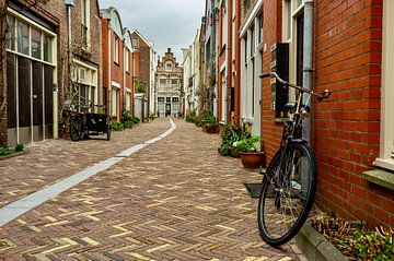 narrow street with bicycle by george vogelaar