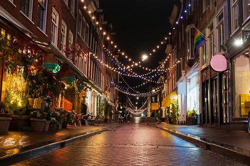 Verlichte winkelstraat in het centrum van Amsterdam