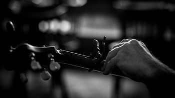 Banjo tuning during the break of an acoustic jam session. Photographed with a vintage manual focus l