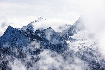 Hoge bergtoppen in de alpen omringd door wolken