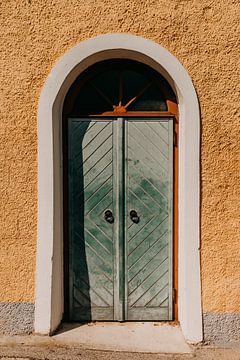 Blue-green pastel door and yellow wall in Hallstatt (Austria) by Yvette Baur