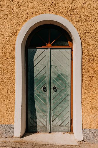 Blauw groene pastel deur en gele muur in Hallstatt (Oostenrijk)