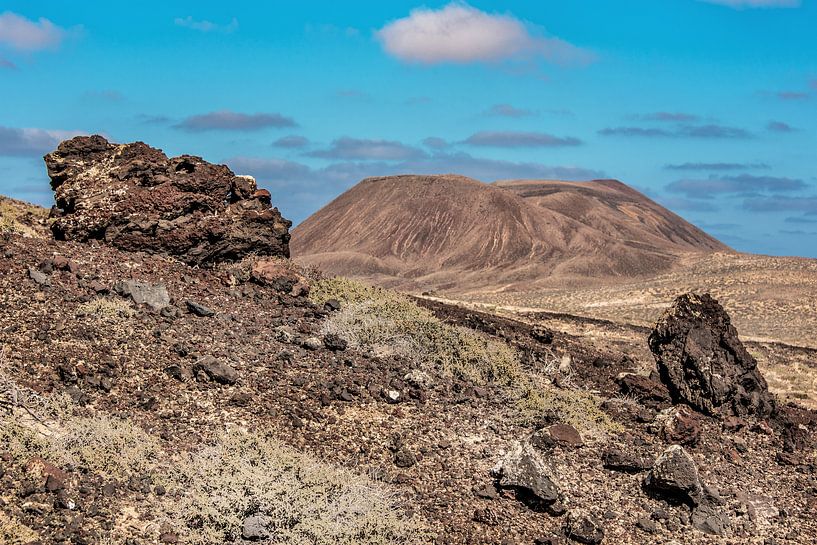 Landschap Lanzarote met lava rotsblokken op de voorgrond. van Harrie Muis