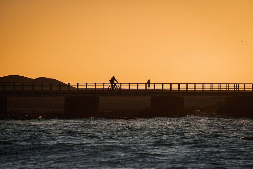 Silhouette of a cyclist during sunset by Vrijgeworteld