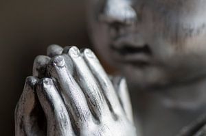 Namasté. Gros plan des mains et du visage d'un Bouddha en argent